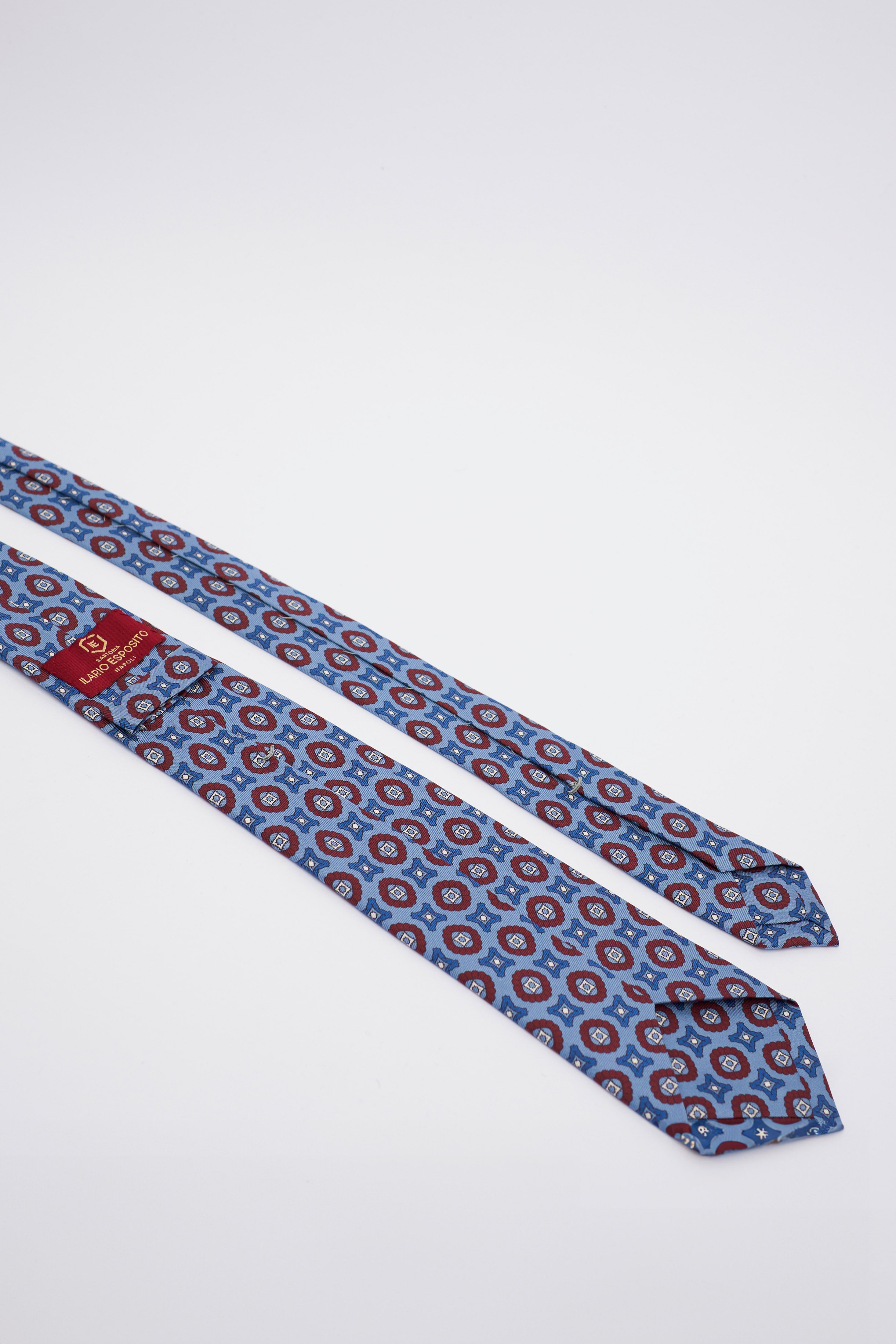 Cravatta in Seta Celeste Spento con Disegno Geometrico Blu e Rosso